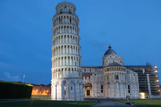 Pisa, Italy - 01 July 2023: leaning tower and cathedral panorama by night, blue sky