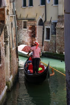 Venice, Italy - September 5, 2022: One of the most recognizable tourist attractions in the world - a gondola cruise through the narrow canals in Venice