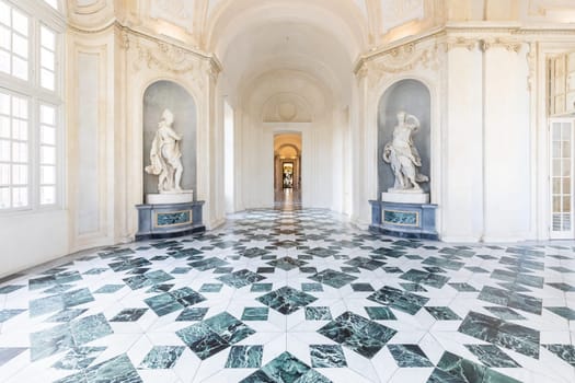 Venaria Reale, Italy - January 2023: luxury interior old royal palace. Gallery perspective with window