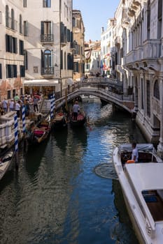 Venice, Italy - September 5, 2022: One of the most recognizable tourist attractions in the world - a gondola cruise through the narrow canals in Venice