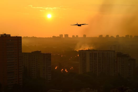Plane drone over burning city at sunset or sunrise. Neural network generated image. Not based on any actual scene or pattern.
