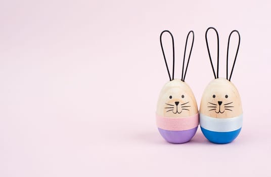 Easter bunny or rabbit couple cuddle together, wooden egg, spring holiday greeting card