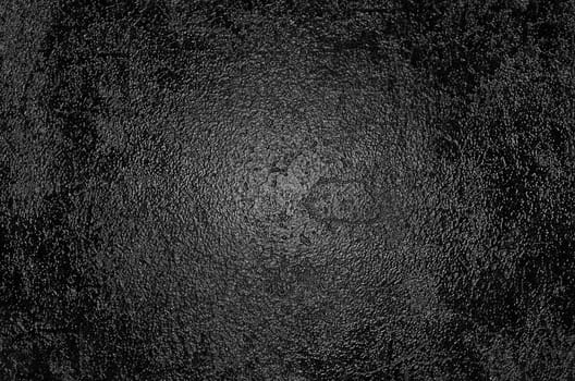 A rough glossy black surface with an illuminated center