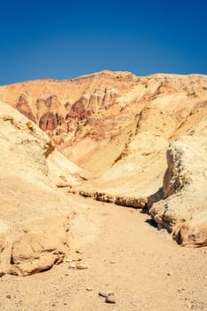 Hiking trail through the Golden Canyon with the view of Red Cathedral rock formations in Death Vallley National Park in California