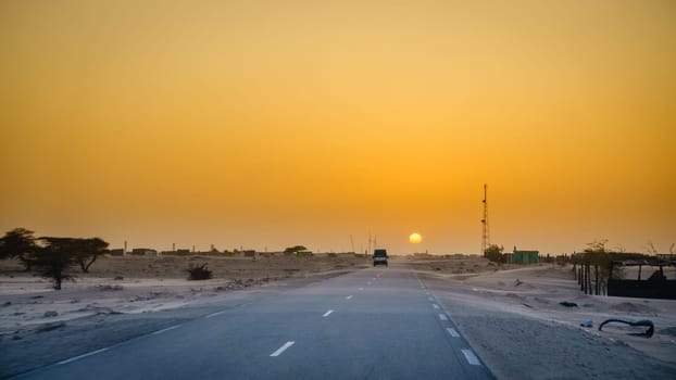 Driving through a village in the desert in Mauritania at sunset