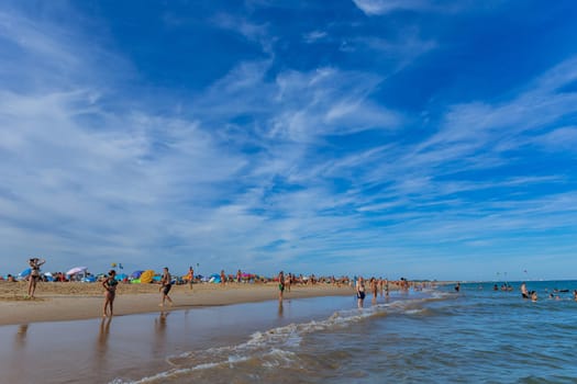 Tavira, Portugal - August 15, 2023: People at the famous beach of Tavira island in Tavira. This beach is a part of famous tourist region of Algarve.