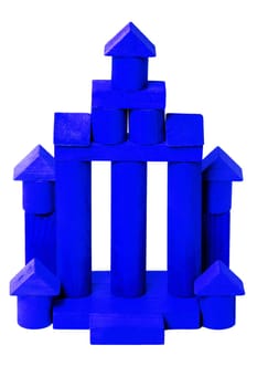 Wooden house isolated. Wooden toy castle constructed of cubes, cylinders, triangles and other shapes. Childrens wooden toy blocks.Macro.