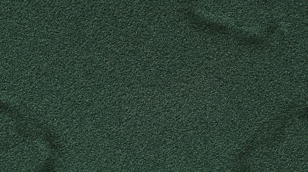 Background texture of a green rough relief mottled surface of dark green color close-up view from above