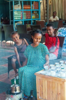 Melkasa, Ethiopia - April 27, 2019: Woman perform a traditional Ethiopian coffee ceremony, preparing street bunna coffee.