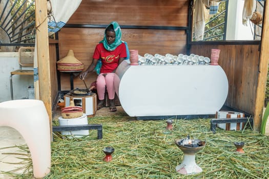 Ziway, Ethiopia - April 27, 2019: Woman perform a traditional Ethiopian coffee ceremony, preparing street bunna coffee.