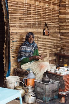 Oromia Region, Ethiopia - April 27, 2019: Woman perform a traditional Ethiopian coffee ceremony, preparing street bunna coffee.