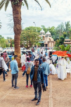 Bahir Dar, Ethiopia - April 21st, 2019: Orthodox Christian people white dressed walk to mass on the street during Easter holiday reflecting the traditions and festive atmosphere of the occasion.