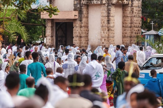 Bahir Dar, Ethiopia - April 21st, 2019: Orthodox Christian people white dressed walk to mass on the street during Easter holiday reflecting the traditions and festive atmosphere of the occasion.