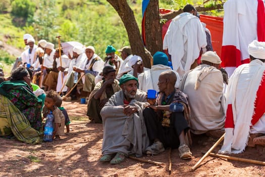 Lalibela, Ethiopia - May 1, 2019: Orthodox Ethiopians unwind at St. George Church after Mass. A serene moment capturing faith and cultural richness.