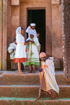Lalibela, Ethiopia - May 1, 2019: Orthodox Ethiopians unwind at St. George Church after Mass. A serene moment capturing faith and cultural richness.