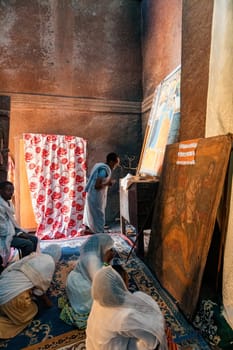 Lalibela, Ethiopia - May 1, 2019: A poignant image of worshippers praying inside St. George Church, Lalibela, capturing the spiritual devotion on May 1, 2019.