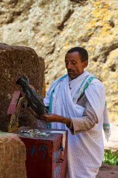 Lalibela, Ethiopia - May 1, 2019: Man counts collected funds from the faithful outside St. George Church, Lalibela, shedding light on the financial support within the religious community.
