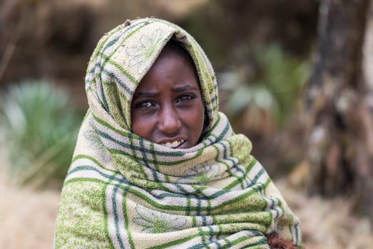 SIMIEN MOUNTAIN, ETHIOPIA, APRIL 25.2019, Little Ethiopian shepherdess girl veiled in a blanket in cold morning. Simien Mountains, Ethiopia, April 25. 2019