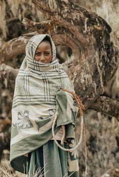 SIMIEN MOUNTAIN, ETHIOPIA, APRIL 25.2019, Little Ethiopian shepherdess girl veiled in a blanket in cold morning. Simien Mountains, Ethiopia, April 25. 2019