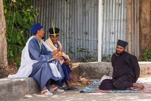 Bahir Dar, Ethiopia - April 21, 2019: Group of Orthodox monk resting in shadows Tana Haik Entons Eysus United Monastery on lake Tana near Bahir Dar. Ethiopia Africa