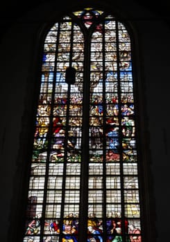 Gouda, the Nehterlands - April 20, 2023: The Stained glass number 23 - Elijah, with foot washing and with portrait of the donor, the Duchess of Parma by Wouter Crabeth in the Sint Janskerk