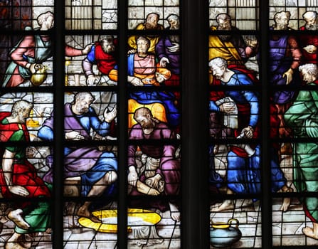 Gouda, the Nehterlands - April 20, 2023: The Stained glass number 23 - Elijah, with foot washing and with portrait of the donor, the Duchess of Parma by Wouter Crabeth in the Sint Janskerk