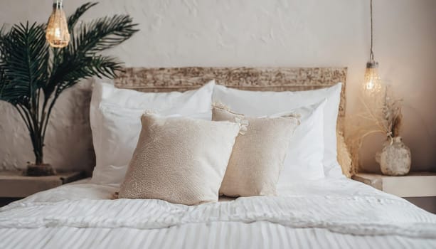 Clean Bedding sheets and pillow on natural wall room background. White bedding and pillow in hotel room. White pillows on empty bed.