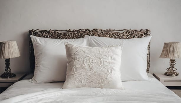 Clean Bedding sheets and pillow on natural wall room background. White bedding and pillow in hotel room. White pillows on empty bed.
