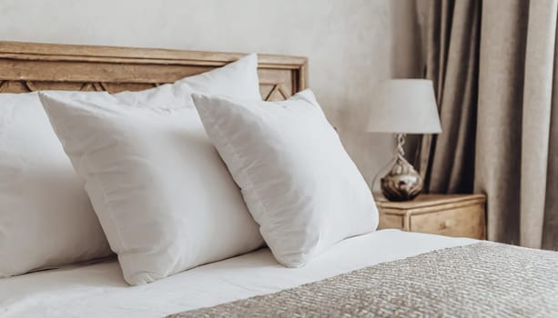 Clean Bedding sheets and pillow on natural wall room background. White bedding and pillow in hotel room. White pillows on empty bed.