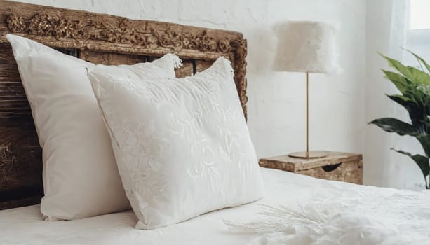 Clean Bedding sheets and pillow on natural wall room background. White bedding and pillow in hotel room. White pillows on empty bed.