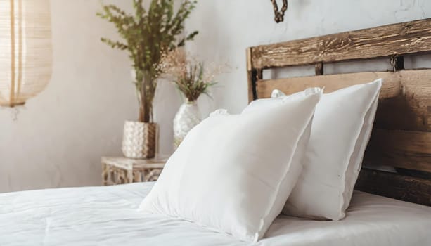Clean Bedding sheets and pillow on natural wall room background. White bedding and pillow in hotel room. White pillows on empty bed.
