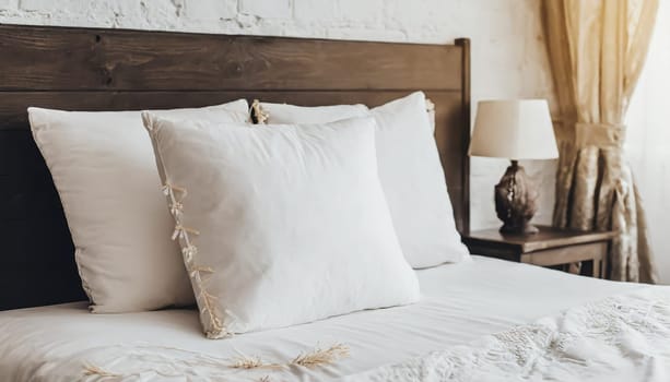 Clean Bedding sheets and pillow on natural wall room background. White bedding and pillow in hotel room. White pillows on empty bed.