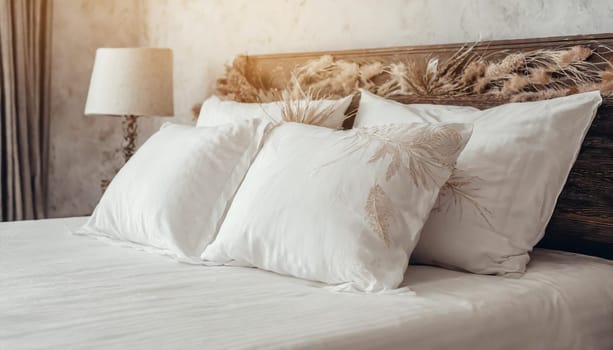 Clean Bedding sheets and pillow on natural wall room background. White bedding and pillow in hotel room. White pillows on empty bed.