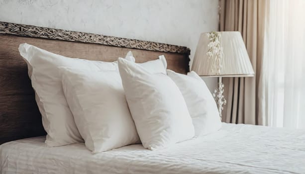 Clean Bedding sheets and pillow on natural wall room background. White bedding and pillow in hotel room. White pillows on empty bed.