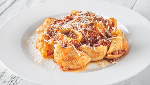 Portion of lumaconi pasta with bolognese sauce