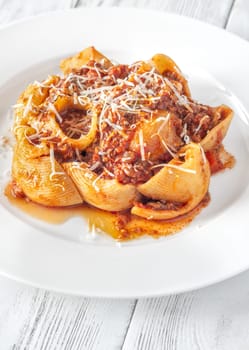 Portion of lumaconi pasta with bolognese sauce