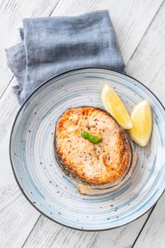 Portion of cooked salmon medallion with lemon