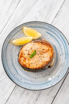 Portion of cooked salmon medallion with lemon