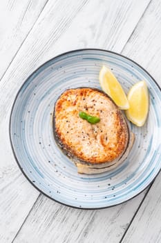 Portion of cooked salmon medallion with lemon