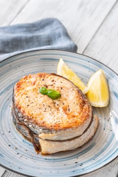 Portion of cooked salmon medallion with lemon