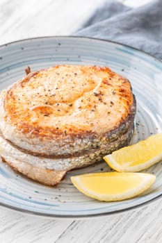 Portion of cooked salmon medallion with lemon