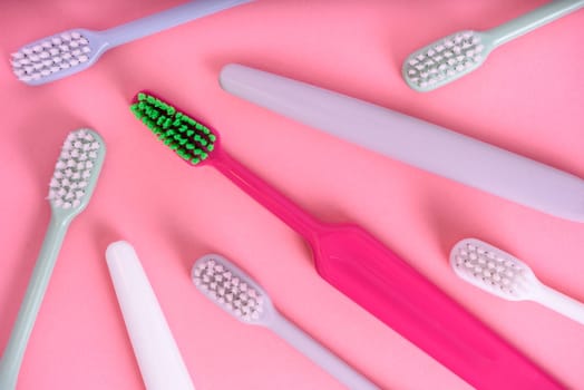 Different pastel tooth brushes pattern on color background. Many toothbrush choices for dental care and oral prevention hygiene. Family teethcare dentist concept. Minimal flat lay.