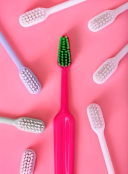 Different pastel tooth brushes pattern on color background. Many toothbrush choices for dental care and oral prevention hygiene. Family teethcare dentist concept. Minimal flat lay.