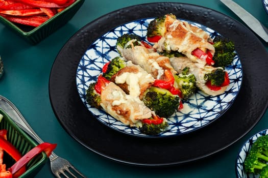 Roast pork meat roll with broccoli and bell pepper. Hot appetizing meal.