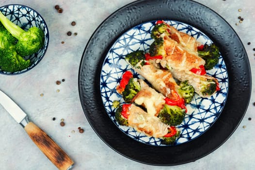 Roast pork meat roll with broccoli and bell pepper. Hot appetizing meal.