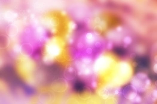 A festive abstract delicate Happy New Year or Christmas background texture with colorful gold yellow pink blurred bokeh lights and stars. Space for design. Card concept or advertising.