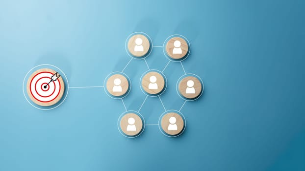 Circular wood with printed target icons and business symbols on light blue background, business goals and objectives concept, business competition, Customer relationship management concept.