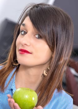 a young woman showing an apple
