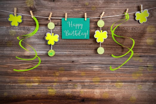Saint Patrick's Day Green Label With English Text Happy Birthday! Vintage Wooden Background With Decorative Shamrock And Clover.