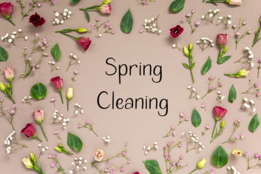 Flower Arrangement With English Text Spring Cleaning. Colorful Spring Blossoms And Flowers Like Roses Building A Frame. Flat Lay With Brown Paper Background
